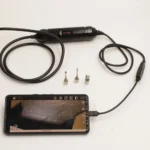 كاميرا فحص Autel MV108S متصلة بهاتف ذكي لفحص اسطوانات المحرك.